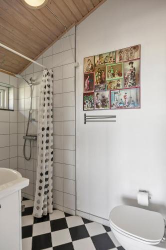 a bathroom with a white toilet and a checkered floor at Rolsø Retreat in Knebel