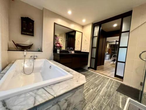 a large bathroom with a tub and a sink at Karon Beach Seaview Penthouse With Private Pool Condominium in Karon Beach