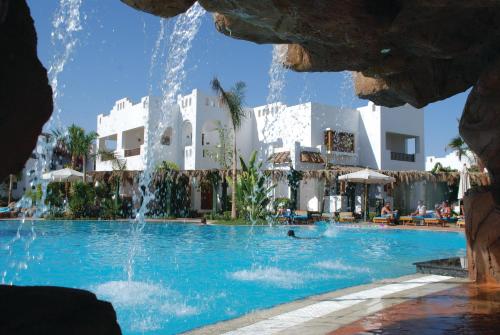 una piscina en un resort con una fuente en Herrmes, en Sharm El Sheikh