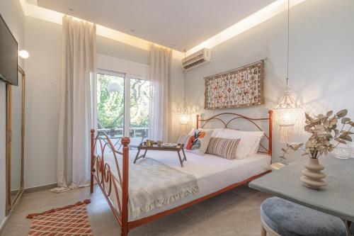 a bedroom with a bed and a table and a window at Rosmari Hotel in Archangelos