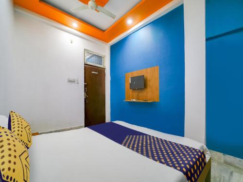 a bedroom with a blue wall and a bed at SPOT ON Hotel Adarsh Palace in Bhopal