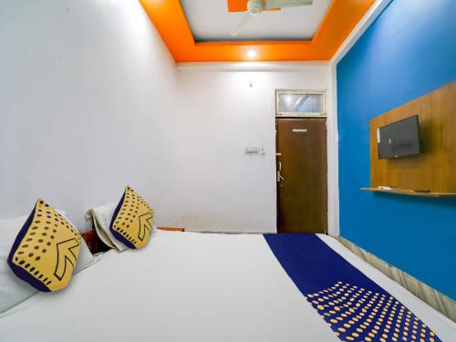 a room with a bed with a blue wall and a door at SPOT ON Hotel Adarsh Palace in Bhopal