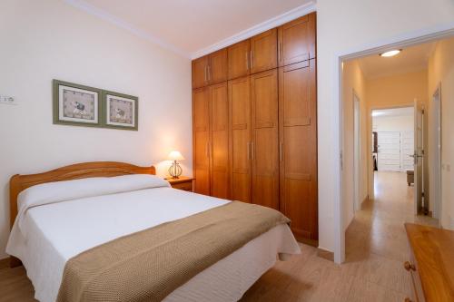 una camera da letto con un letto grande e armadi in legno di Acaymo Sunset a Candelaria