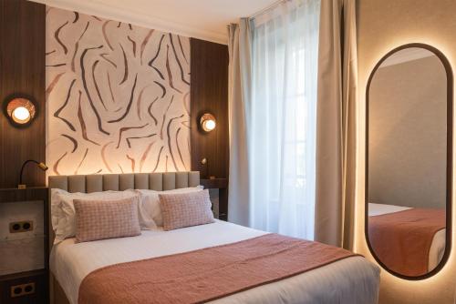 a bedroom with a large bed and a mirror at Best Western Au Trocadéro in Paris