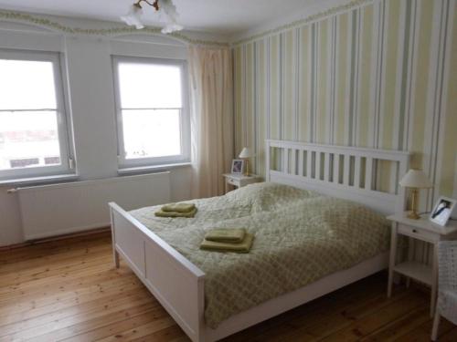 a bedroom with a white bed and two windows at Ferienwohnung Steckelsdorf in Steckelsdorf