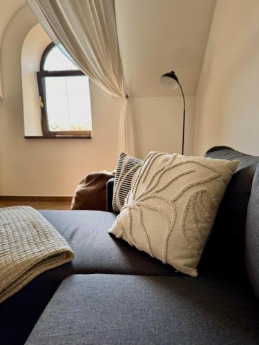 a couch with a pillow in a room with a window at Резиденція на водяному млині in Bogopolʼ