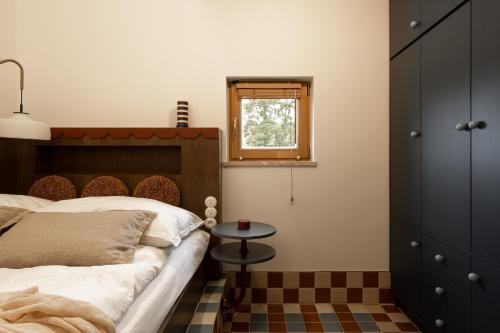 a bedroom with a bed and a table and a window at Kalbornia LAKE & POOL HOUSE by JWPM in Brzeźno Mazurskie