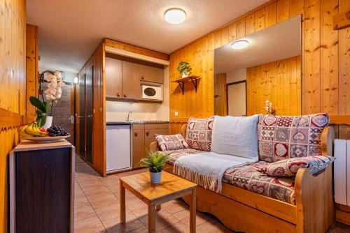 a living room with a couch and a kitchen at Central Apartment In Heart of Val Thorens, Ski In-Out with WiFi in Val Thorens