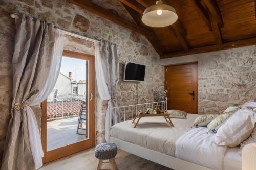 a bedroom with a bed and a sliding glass door at Rustic Villa Kameni dvori heated pool in Sveti Filip i Jakov