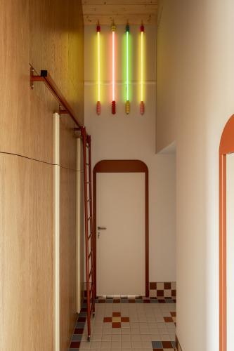 a hallway with a white door with rainbow lights at Kalbornia LAKE & POOL HOUSE by JWPM in Brzeźno Mazurskie