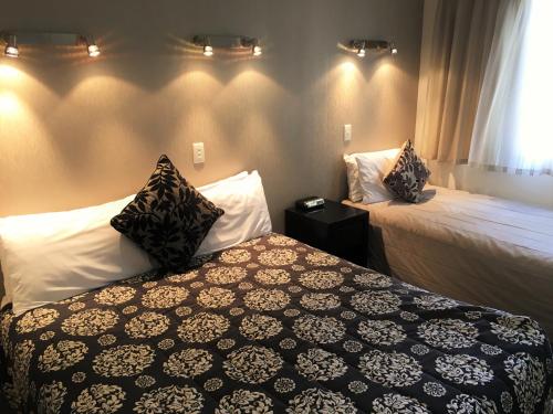 a hotel room with two beds and a window at Cable Court Motel in Dunedin