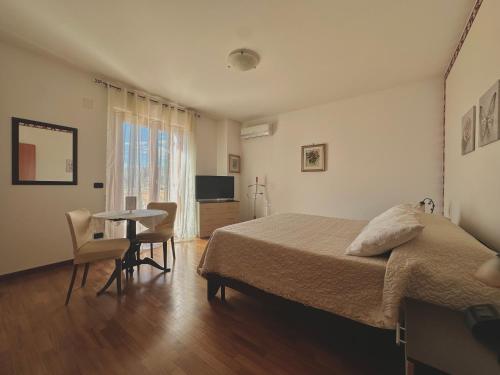 a bedroom with a bed and a table with chairs at B&B Mariposa in Collecorvino