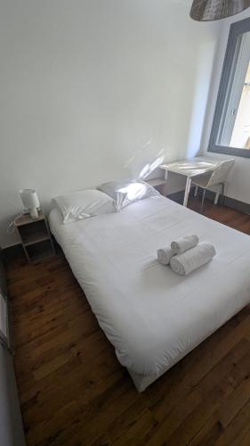 un lit blanc avec deux serviettes dessus dans l'établissement Chambre Privée Lyon Oullins, à Oullins