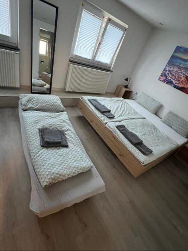 a bedroom with two beds and a mirror at City Apart 2 nahe Badewelt, Museum & Bahnhof mit NETFLIX in Sinsheim