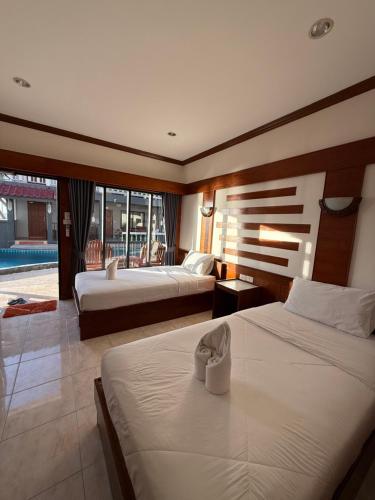 a hotel room with two beds and a balcony at Mr. Black Resort in Haad Rin