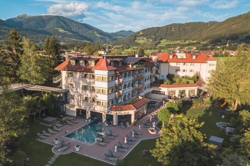 an aerial view of a hotel with a swimming pool at Majestic - Unique Spa Resort in Brunico