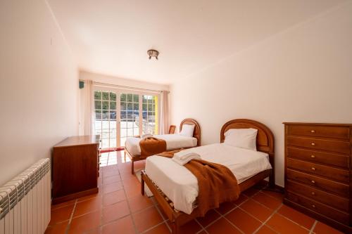 1 Schlafzimmer mit 2 Betten, einer Kommode und einem Fenster in der Unterkunft Burgo D Sancho I 17 in Amoreira