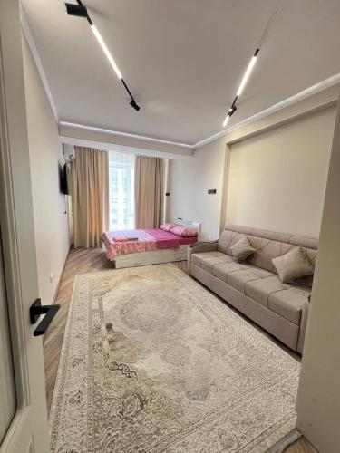 salon z kanapą i dywanem w obiekcie SunHouse w mieście Biszkek