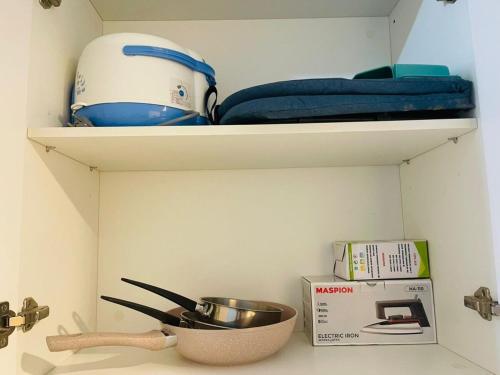 a kitchen shelf with a bowl and a whisk and a box at Skyhouse BSD Apartment studio 2 in Kedeper
