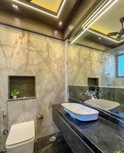 ein Badezimmer mit Waschbecken, Toilette und Spiegel in der Unterkunft Ulvi City in Baku