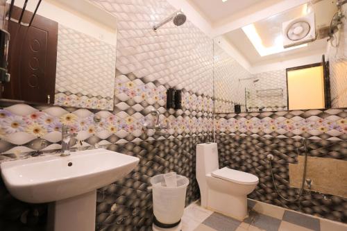 a bathroom with a sink and a toilet at Hotel Mango Tree, Vrindavan in Vrindāvan