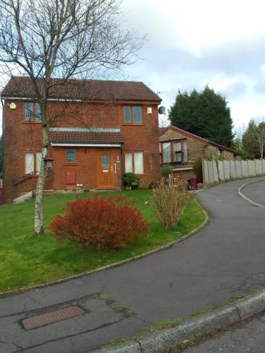 a brick house with a tree and a driveway at Two bedroom home in quite culdisac over looking hospital in Blackburn