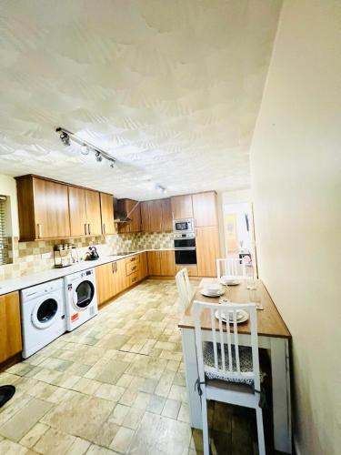 a kitchen with a table and chairs in it at Two bedroom home in quite culdisac over looking hospital in Blackburn