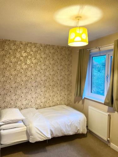 a bedroom with a white bed and a window at Two bedroom home in quite culdisac over looking hospital in Blackburn