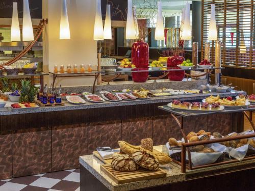 una linea a buffet con molti tipi diversi di cibo di Mövenpick Hotel Frankfurt City Messe a Francoforte sul Meno