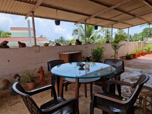 a patio with a table and chairs and monkeys on a wall at Cozy Cabana - Maynard Palace in Benaulim