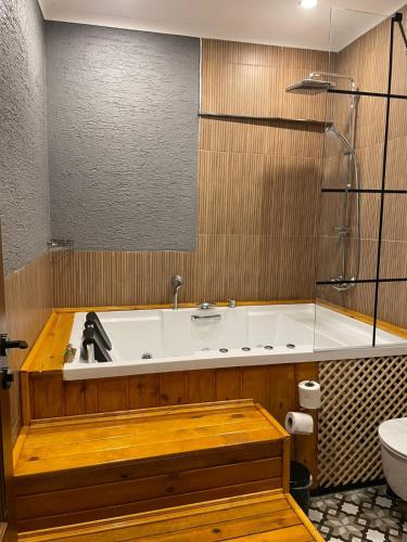 a bathroom with a tub with a sink and a toilet at Navy Inn in Arnavutköy