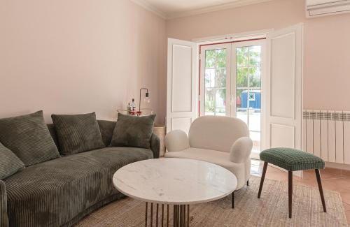 Una sala de estar con un sofá, una mesa y una silla. en Pomegranate Haus, en Melides