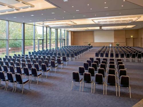 a large room with rows of chairs in a building at Mövenpick Hotel Münster am Aasee in Münster