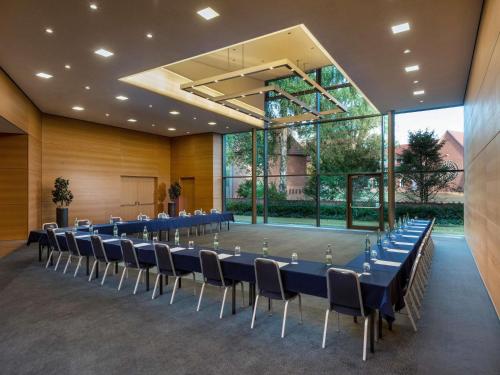 a conference room with a long table and chairs at Mövenpick Hotel Münster am Aasee in Münster