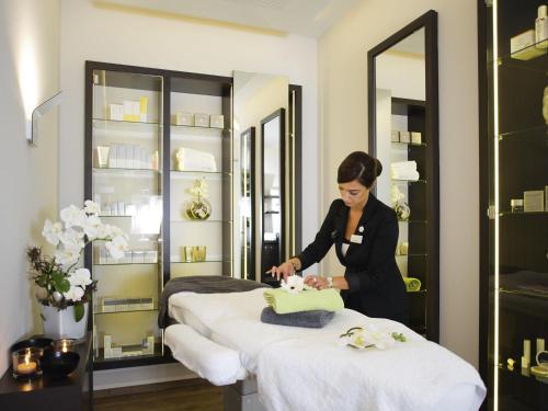 a woman cutting a cake on top of a table at Mövenpick Hotel Münster am Aasee in Münster