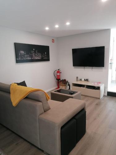 a living room with a couch and a flat screen tv at Casa Gonzaga in Amarante