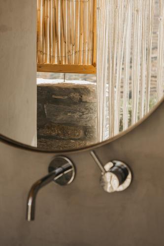 a mirror hanging on a wall with a shower at Kea Villa Thea by A&D Properties in Otzias