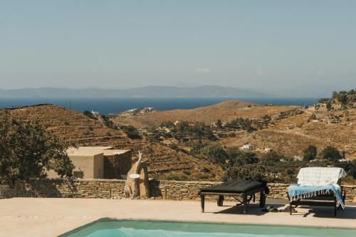 a person standing on a wall next to a swimming pool at Kea Villa Thea by A&D Properties in Otzias