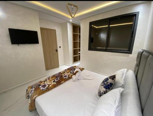 a living room with a white couch and a television at les appartements vip madinat bades alhoceima in Al Hoceïma