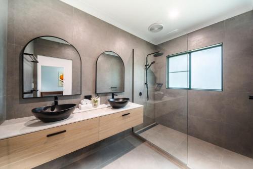 a bathroom with a sink and a mirror and a shower at Beachside on Pacific in Mission Beach