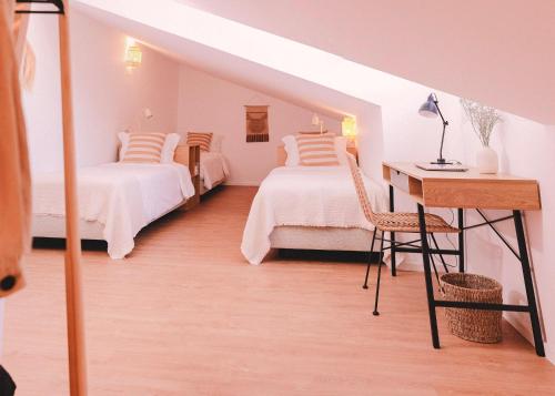 a room with two beds and a desk and a table at Casa Pacata, Beachside Escape in Labruge