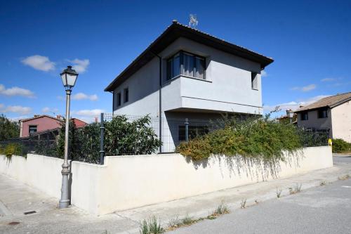 una casa blanca con techo negro y luz de la calle en Casa B, en Basardilla