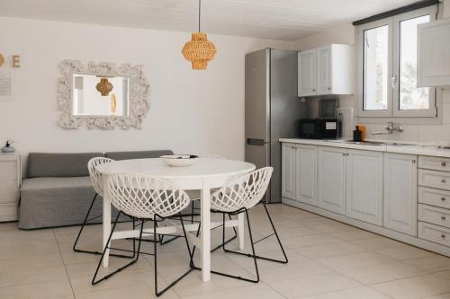 a kitchen with a white table and chairs in a kitchen at Kea Villa Thea by A&D Properties in Otzias