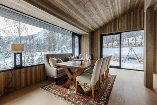 une salle à manger avec une table, des chaises et des fenêtres dans l'établissement Nyørk Chalet, Hemsedal, à Hemsedal