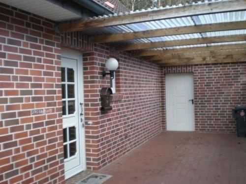 a brick building with awning and a white door at Sögel HA01 in Sögel