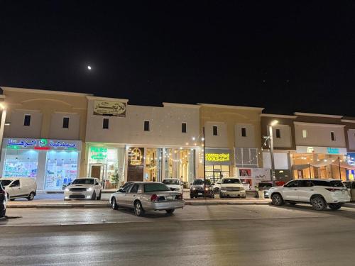 a parking lot with cars parked in front of buildings at Stunn Apartment in Al Kharj