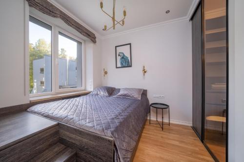 a bedroom with a bed and a window at Forest view front line apartment on Dzintaru avenue in Jūrmala