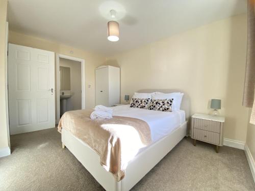 Un dormitorio con una gran cama blanca en una habitación. en Modern 5-Bedroom House in Maidenhead, en Maidenhead