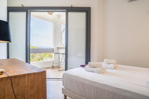 a bedroom with a bed and a view of the ocean at Villa Matutina in Maison Henou