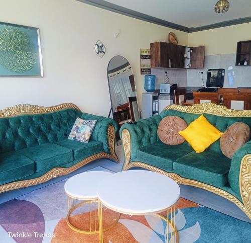 a living room with two green couches and a table at LES INTERNATIONAL in Mombasa